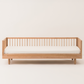Wooden bed frame with white mattress on a light background
