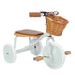Children's tricycle with wooden seat and wicker basket on a white background
